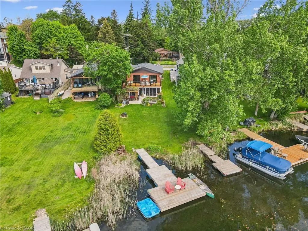 Waterfront property featuring multiple docks, direct water access, and a spacious grassy yard