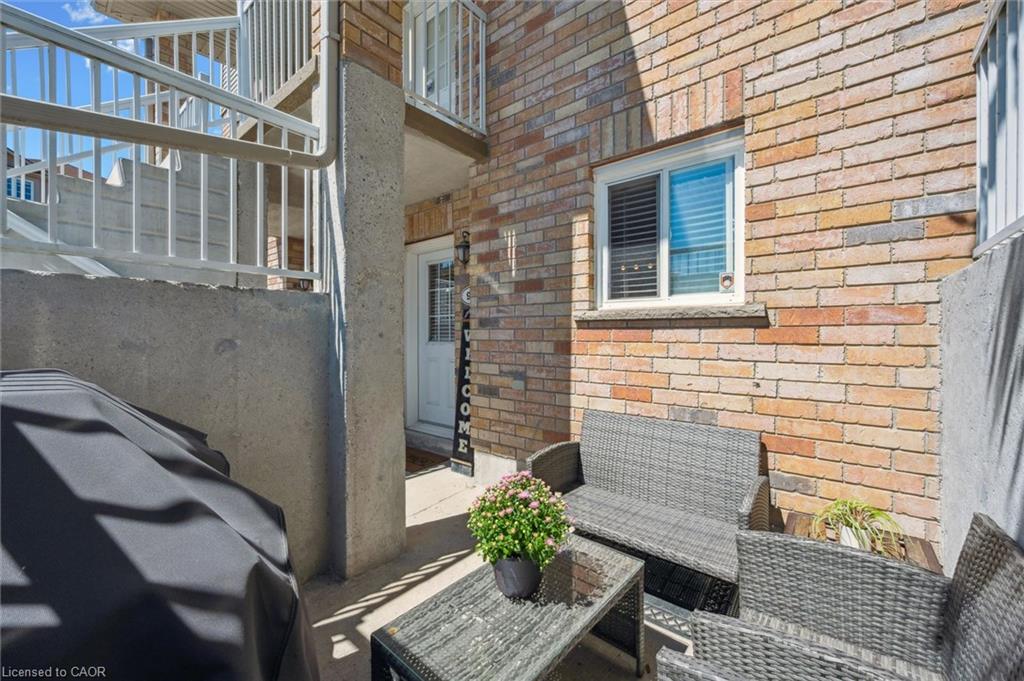 Private patio area featuring brick exterior, white framed window, and concrete privacy wall