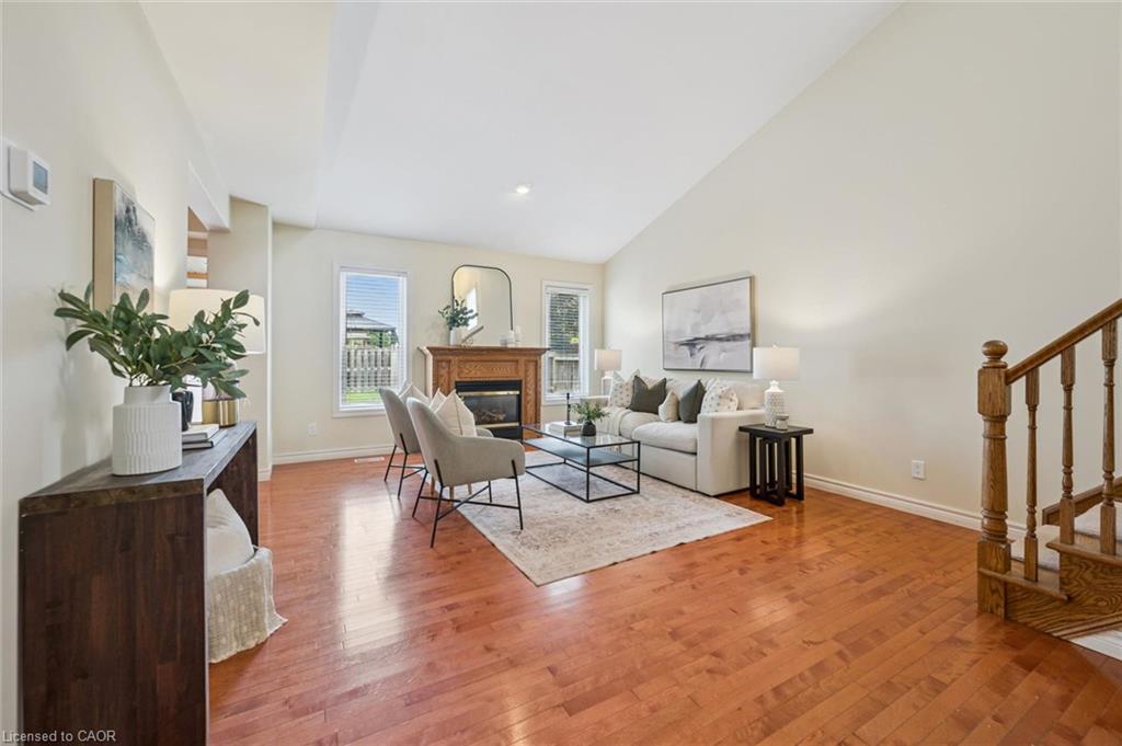 Living room with vaulted ceiling, gas fireplace and hardwood flooring.