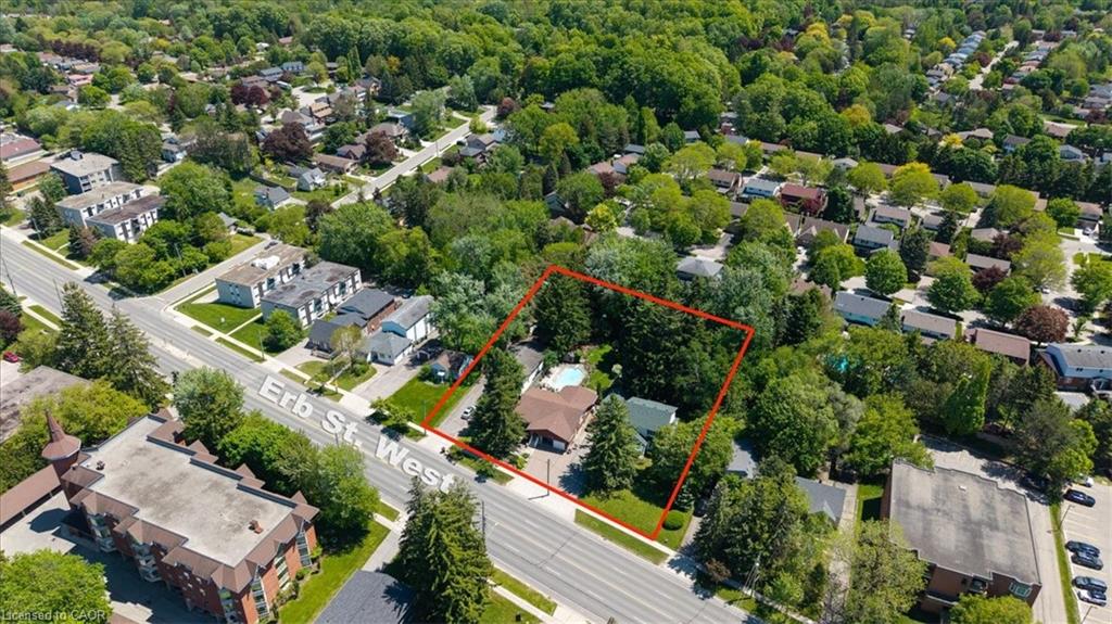 Aerial property with mature trees, a private backyard pool, and road frontage