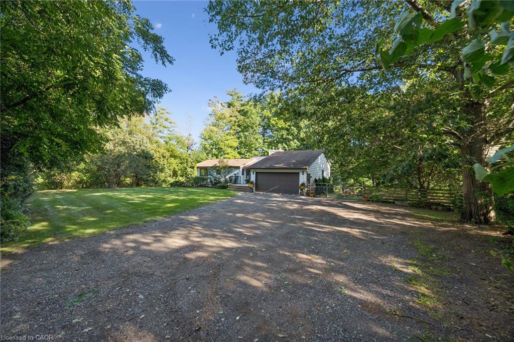 Expansive gravel driveway leading to a single-story residence with a two-car garage