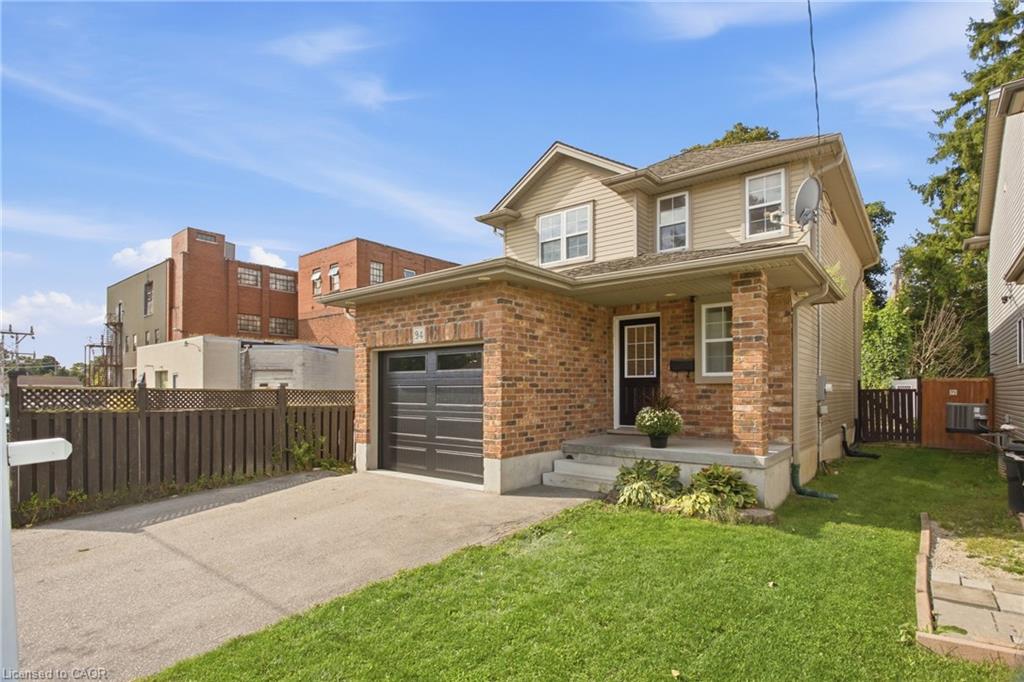 Brick and siding exterior with an attached single-car garage, concrete driveway, and front lawn