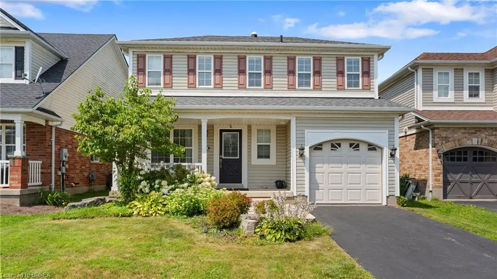 Two-story exterior with light-toned siding, a covered front porch, and a paved driveway leading to an attached garage