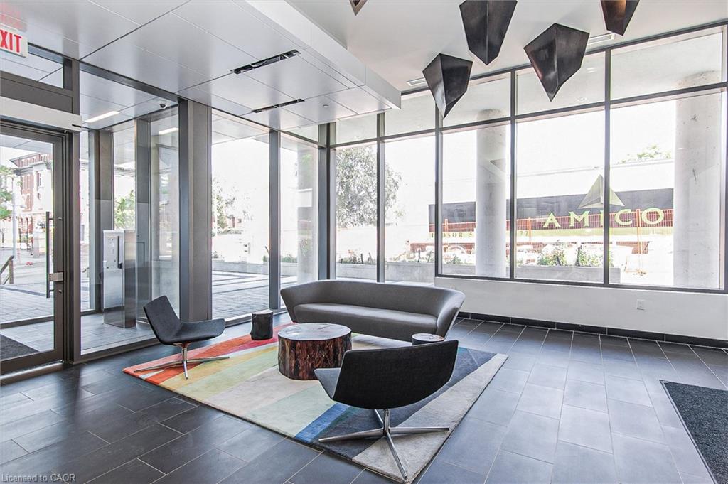 Lobby area featuring full-height windows, dark tile flooring, and recessed ceiling lighting