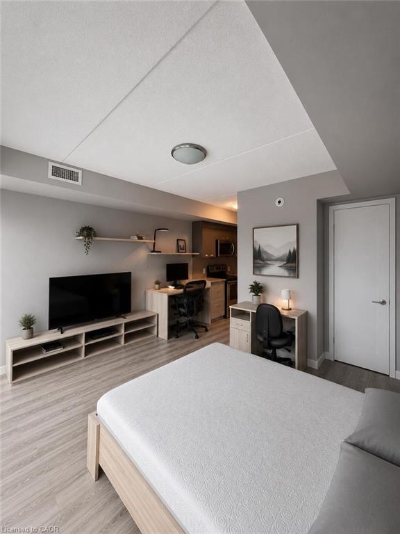 Open-concept living area with wood-finish flooring, light gray walls, and recessed lighting