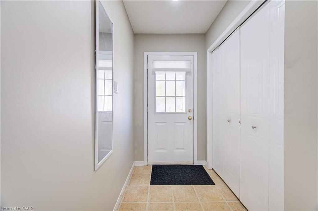 Entryway featuring a paneled door with glass inserts, neutral wall color, and tile flooring
