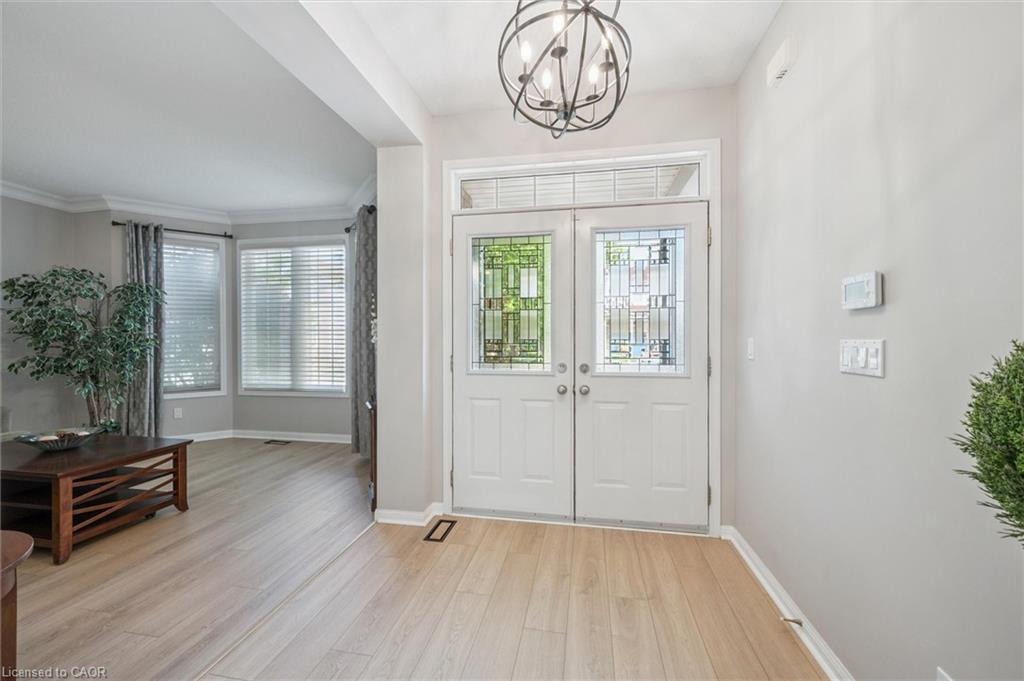Foyer with a chandelier, arches, and Living Room with large windows