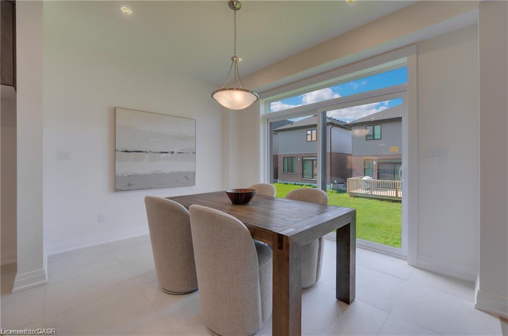 White tile flooring, modern pendant light fixture, expansive sliding glass door, and backyard with green space