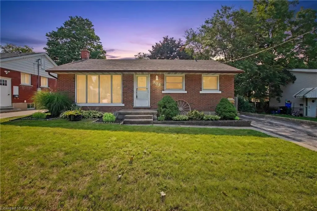 Brick exterior with a prominent front window and mature landscaping