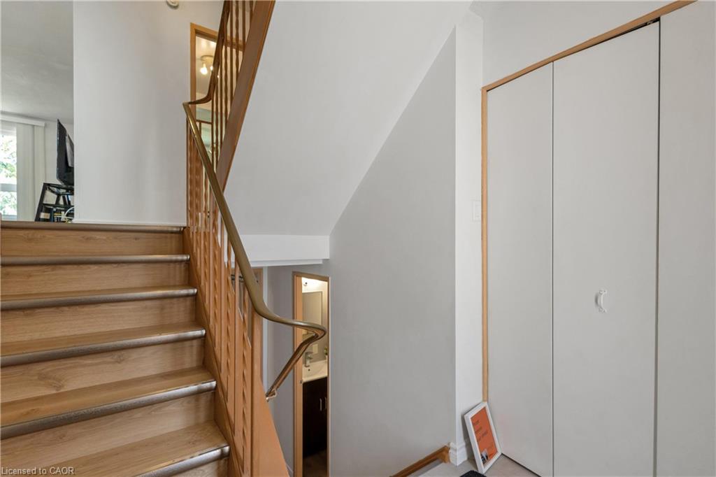 Wood-finish staircase with metal stair nosing, wood balusters, and a curved handrail