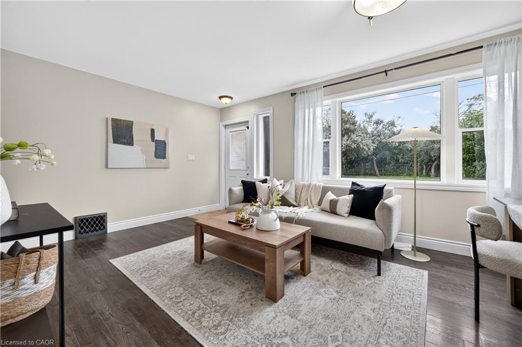 Expansive window, dark wood-finish flooring, recessed lighting, neutral wall tones, and crown molding