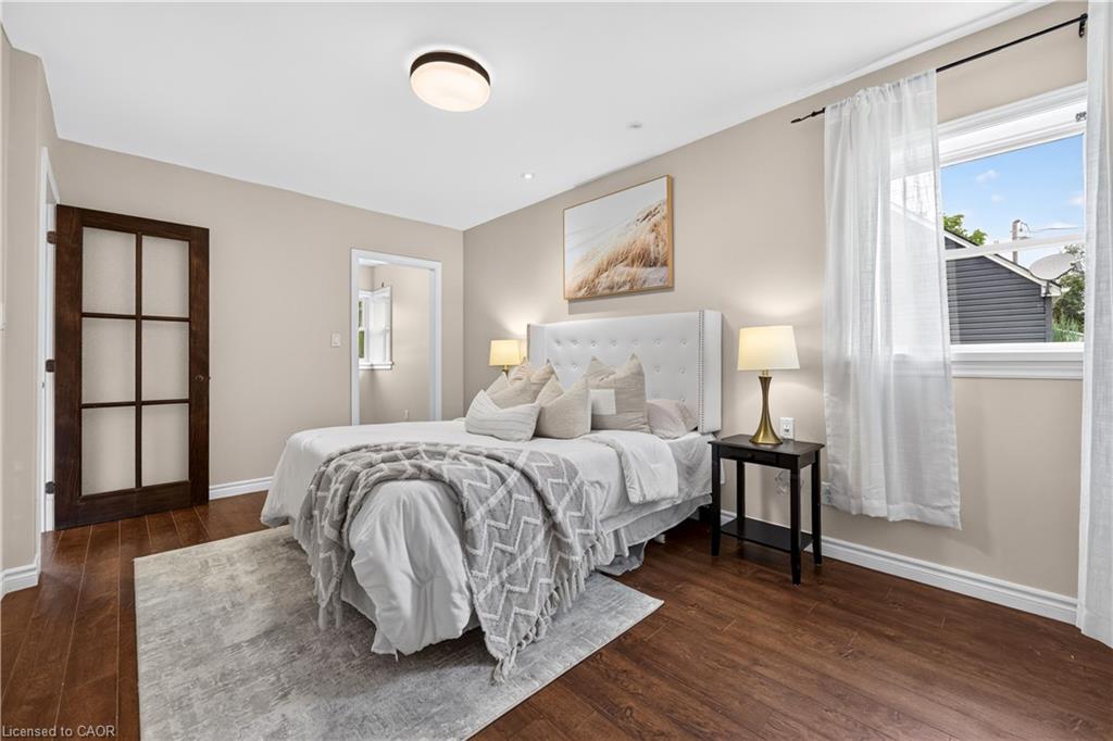 Wood-finish flooring throughout, light neutral paint, and a modern flush-mount ceiling light