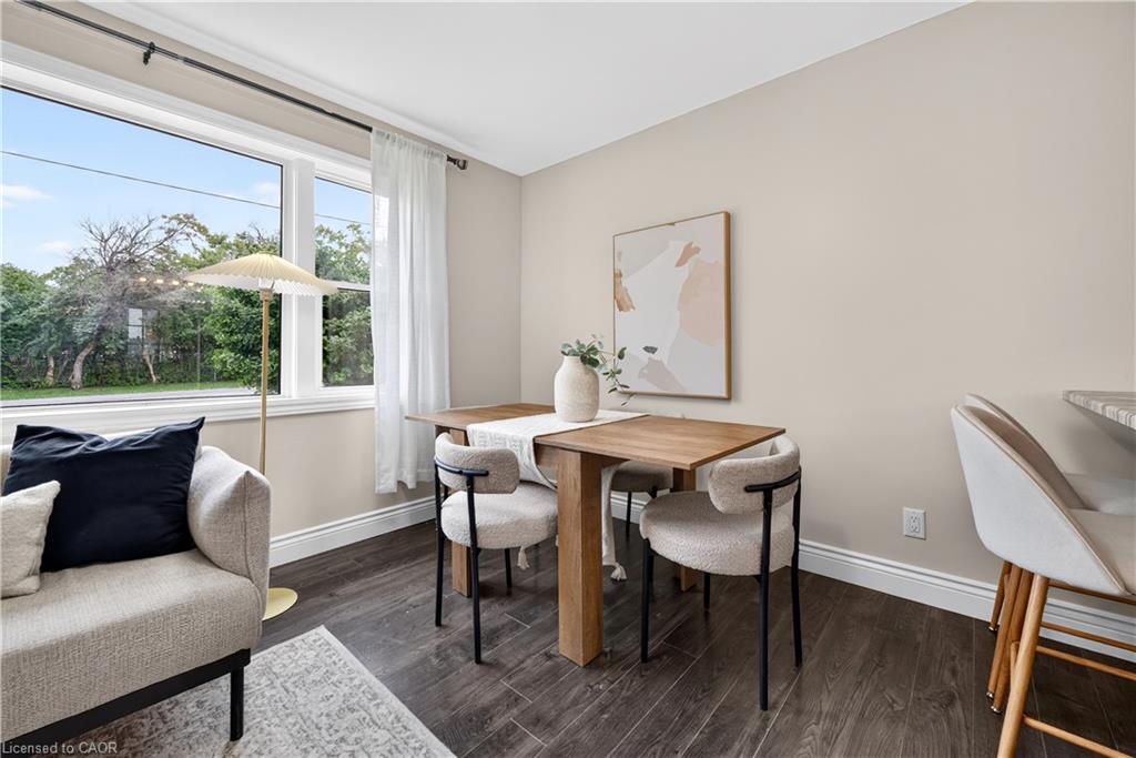 Large picture window, wood-finish flooring, neutral wall tones, white trim, and a breakfast bar