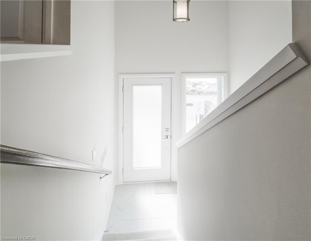 Frosted glass door with sidelight, overhead lighting fixture, and a modern handrail