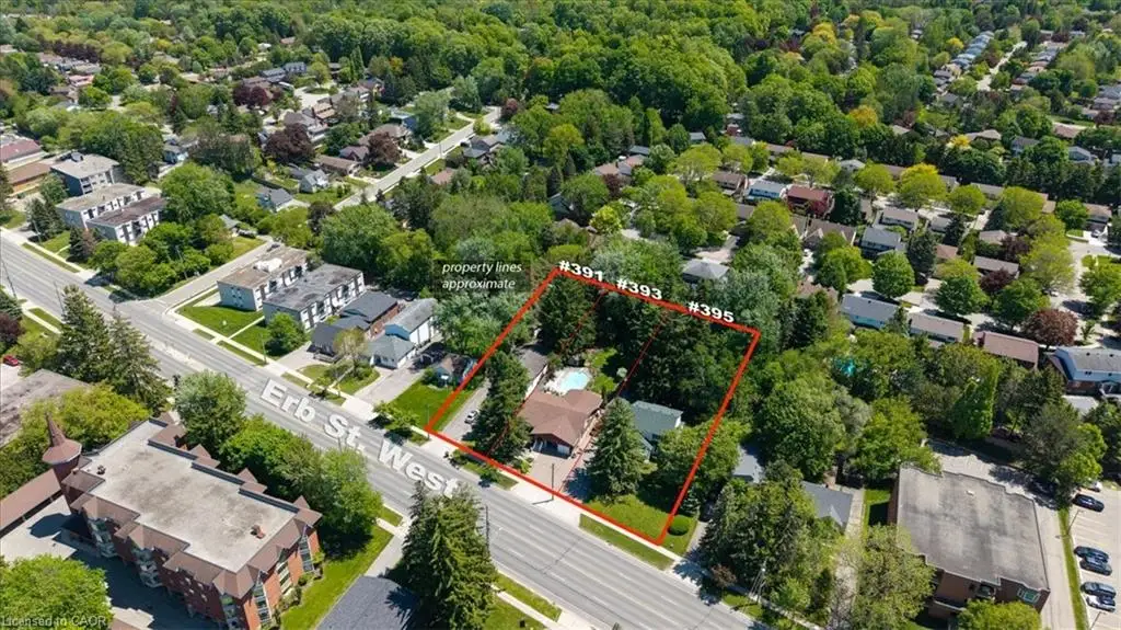 Aerial view of a residential area with dense tree coverage, featuring a property outlined in red
