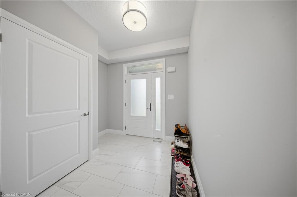 Bright entryway featuring white paneled doors, white baseboards, and light gray walls