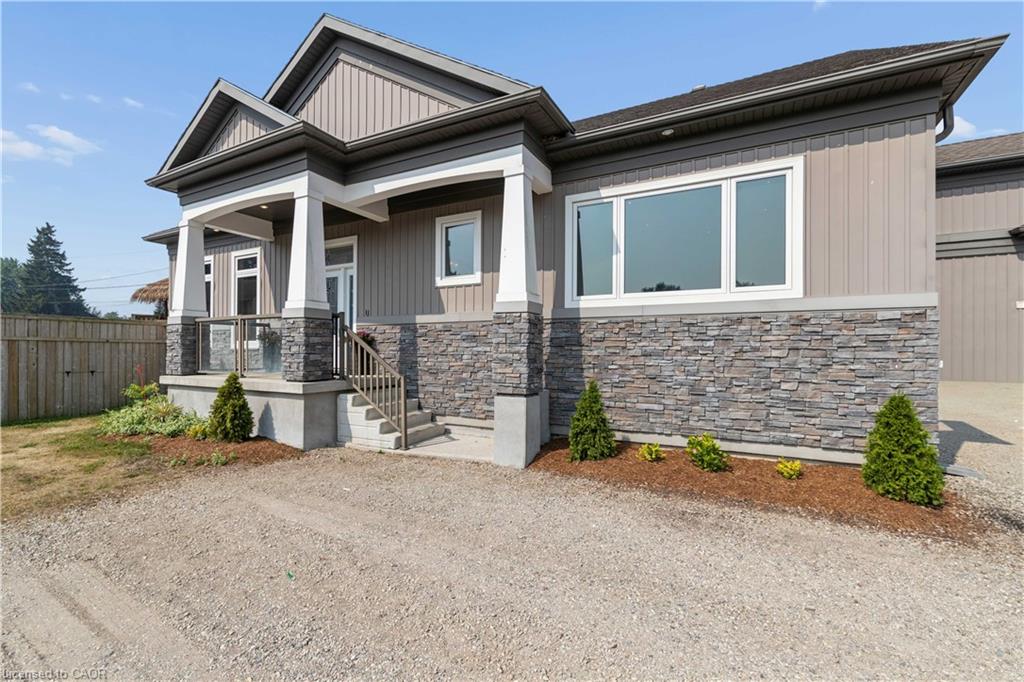 Modern exterior featuring vertical siding, stone accents, white trim, and a covered porch with column supports and glass railings