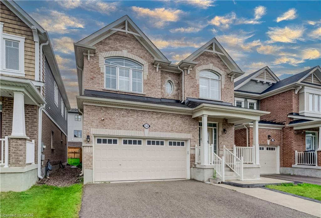 Brick facade with gabled roof lines, attached garage, and covered porch with white railing