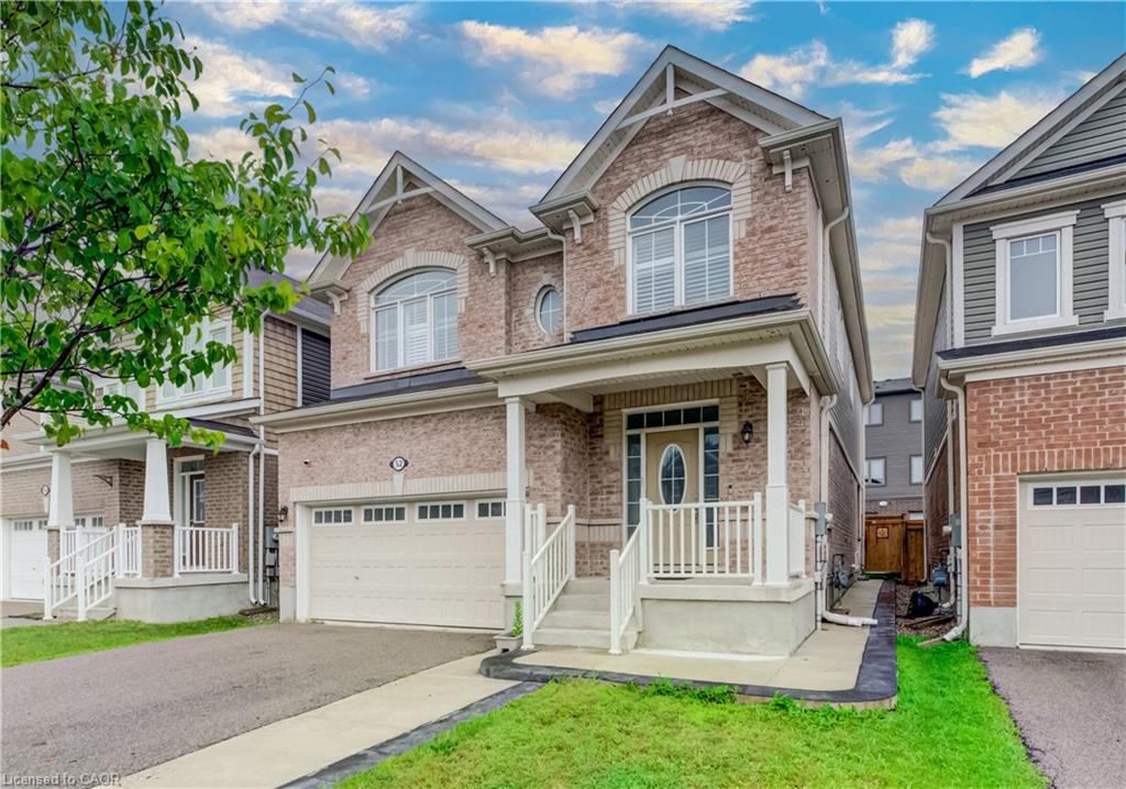 Brick facade, covered front porch, white railing, double garage, arched window