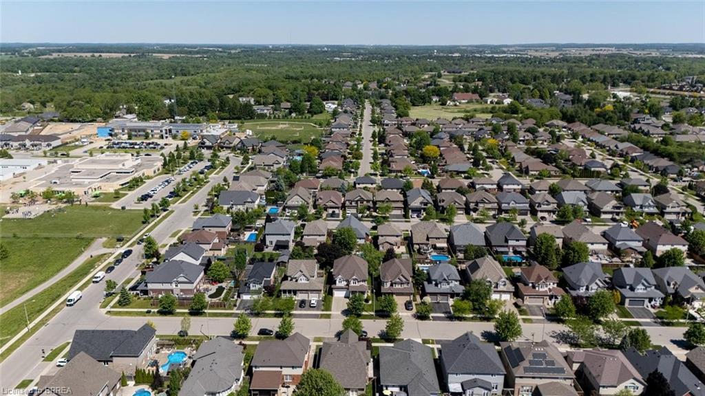 Aerial perspective of a suburban neighborhood featuring residential homes, paved streets, and green spaces