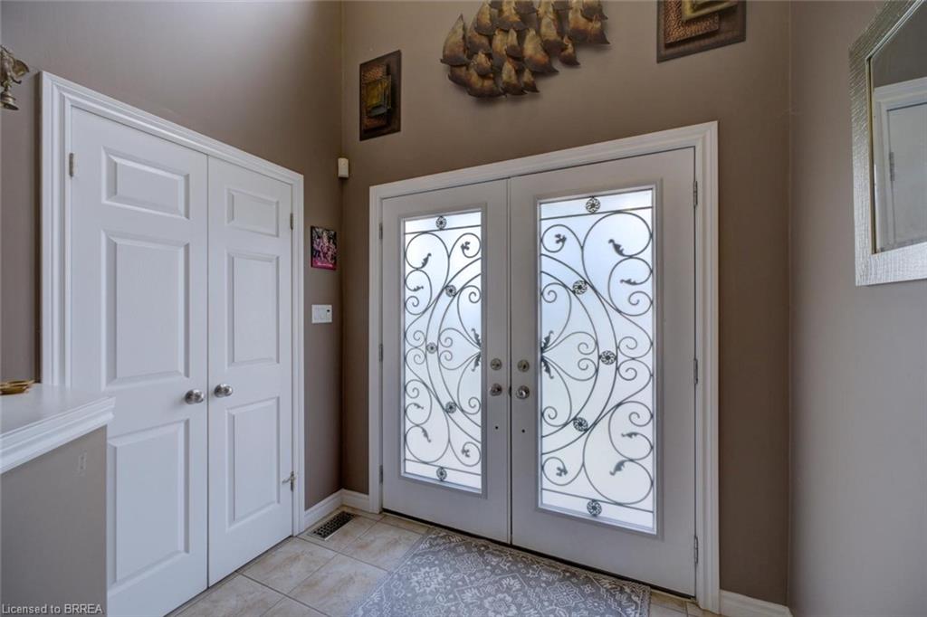 Double entry doors featuring decorative wrought iron and frosted glass panels