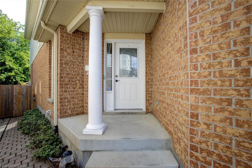 Brick exterior with a white entry door, fluted column, and concrete porch