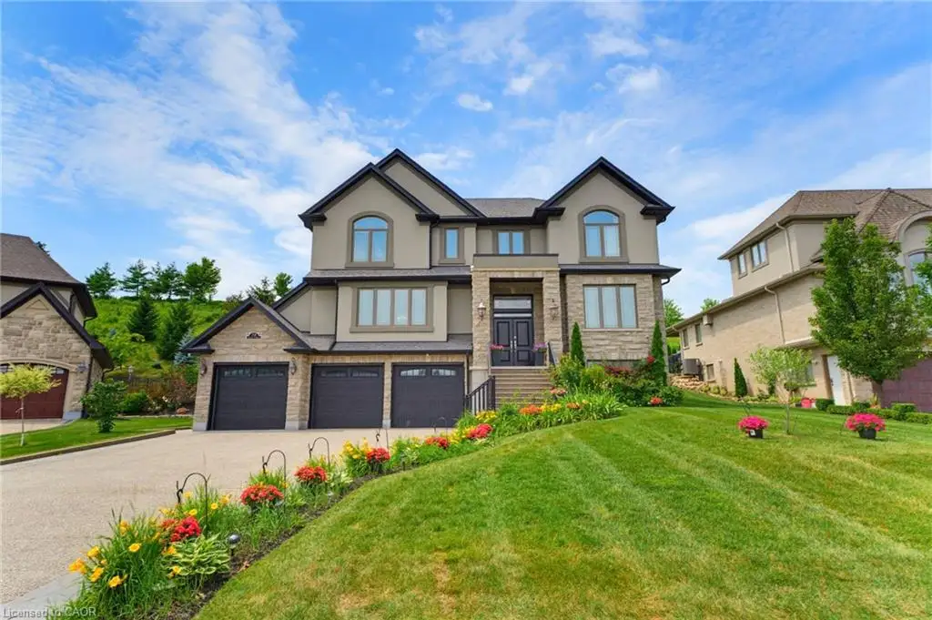 Stately two-story residence featuring a stone and stucco exterior