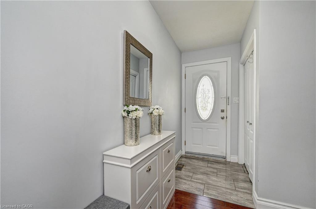 Entryway featuring a white door with an oval decorative glass insert, complemented by light gray wall paint