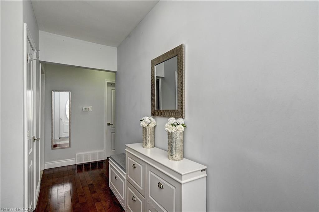 Hardwood flooring extending through the entry, neutral wall tones, and white trim