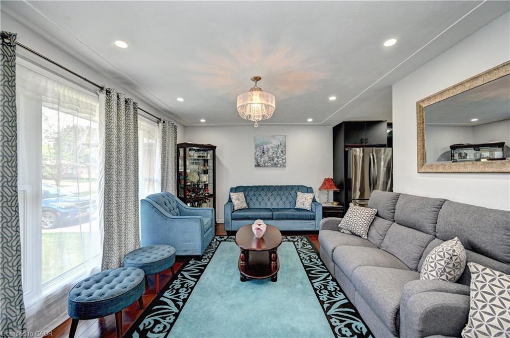 Bright living space with recessed lighting and a central chandelier