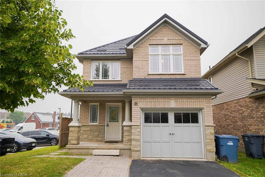 Brick exterior with stone accents, covered front porch, integrated garage, and a dark tile roof