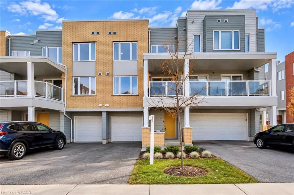 Contemporary townhouse exterior featuring a mix of brick and horizontal siding, covered balconies with glass railings, and multiple attached garage bays