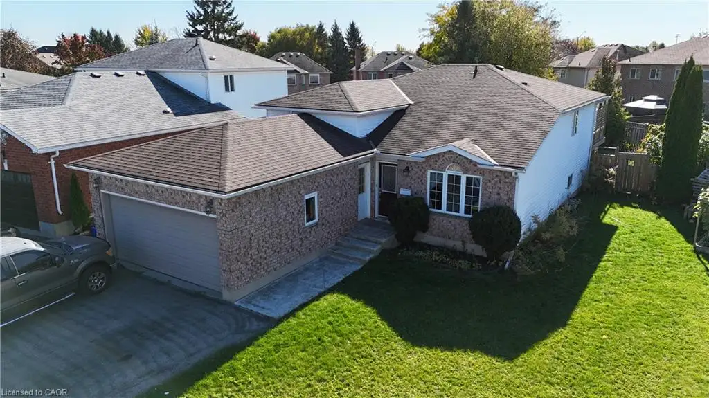 Single-story residential exterior featuring brick and vinyl siding, an attached garage, shingled roof, concrete walkway, and an open lawn area