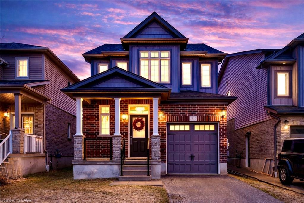 Craftsman-style house featuring asphalt driveway, a porch, a garage, and brick siding