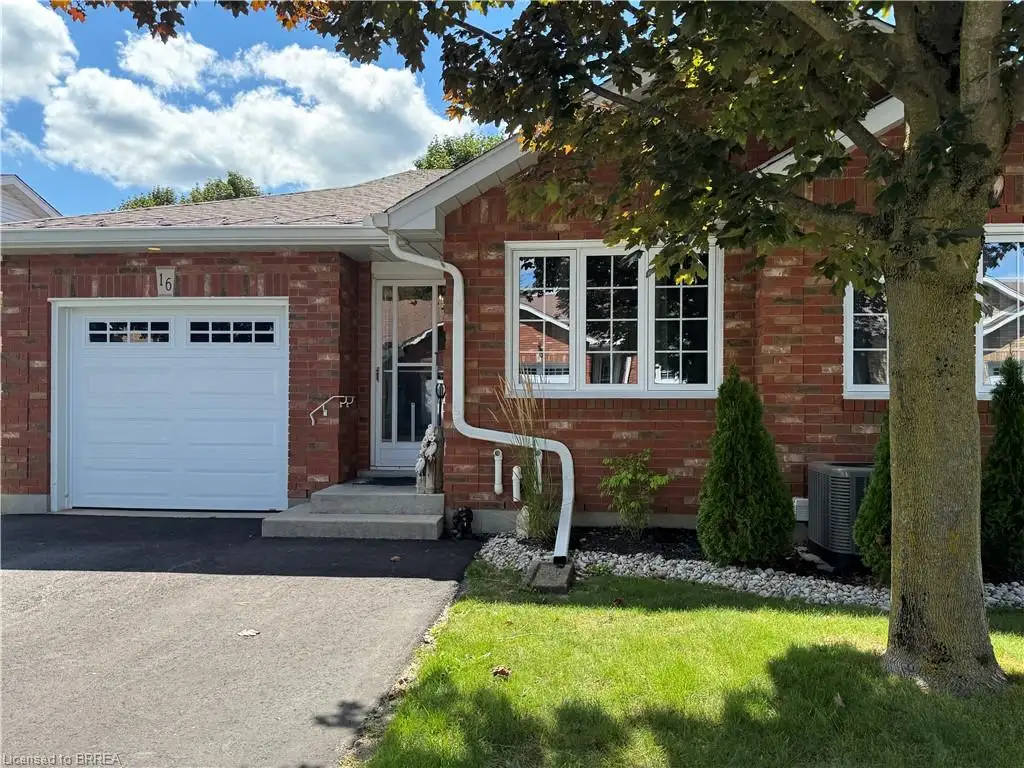 front of unit featuring 2 parkings spots plus garage parking, mature landscaping