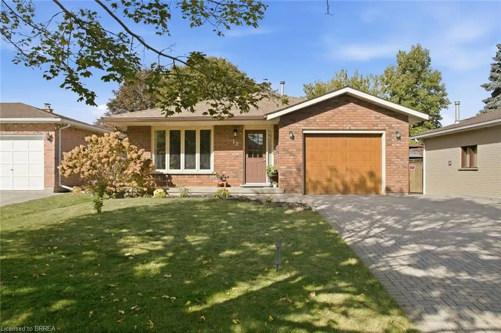 Brick exterior featuring a multi-pane bay window, attached one-car garage, concrete front stoop, and interlocking paver driveway