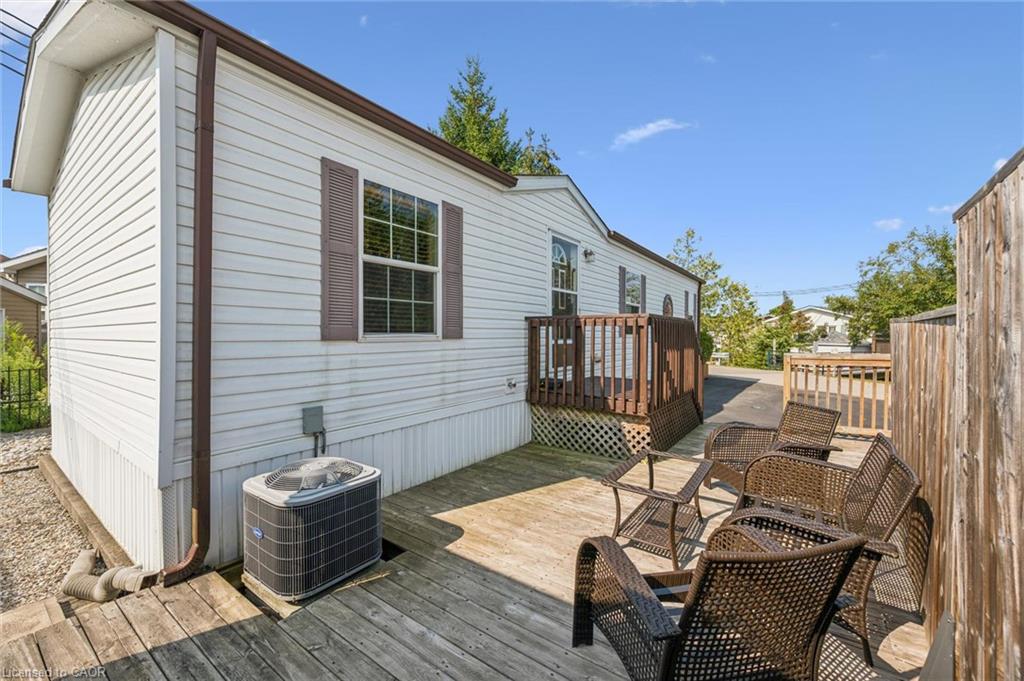 Exterior with white siding and brown shutters, featuring a wooden deck with railing