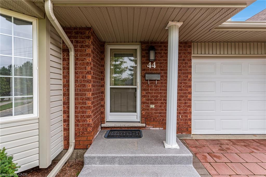 Brick exterior with a white garage door, large bay window, and covered entry