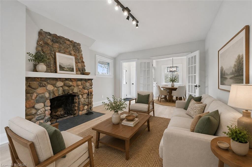 Elegant living room anchored by a striking stacked-stone fireplace with a dark hearth and mantel shelving