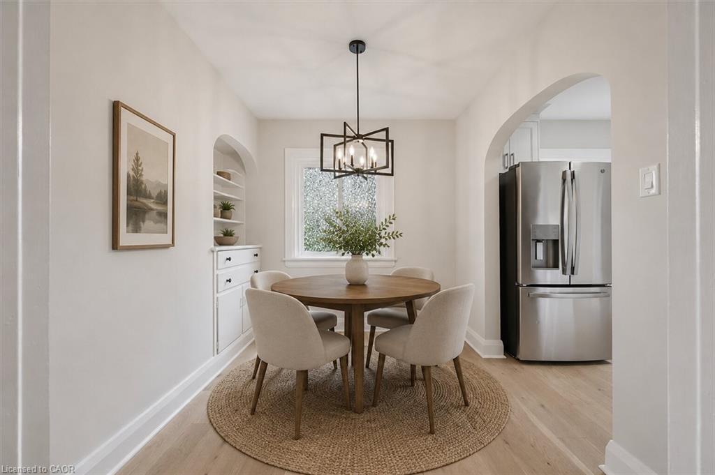 Bright dining area featuring a round wood-finish table, neutral upholstered chairs, and a natural jute area rug