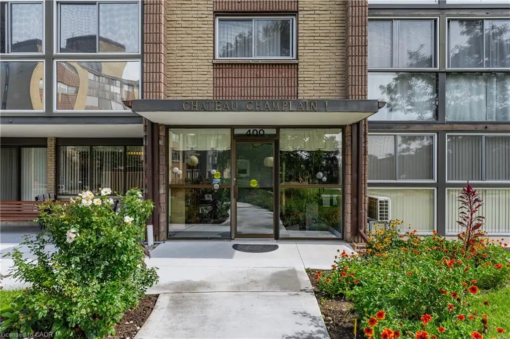 Brick exterior with large windows, covered entrance, and mature landscaping