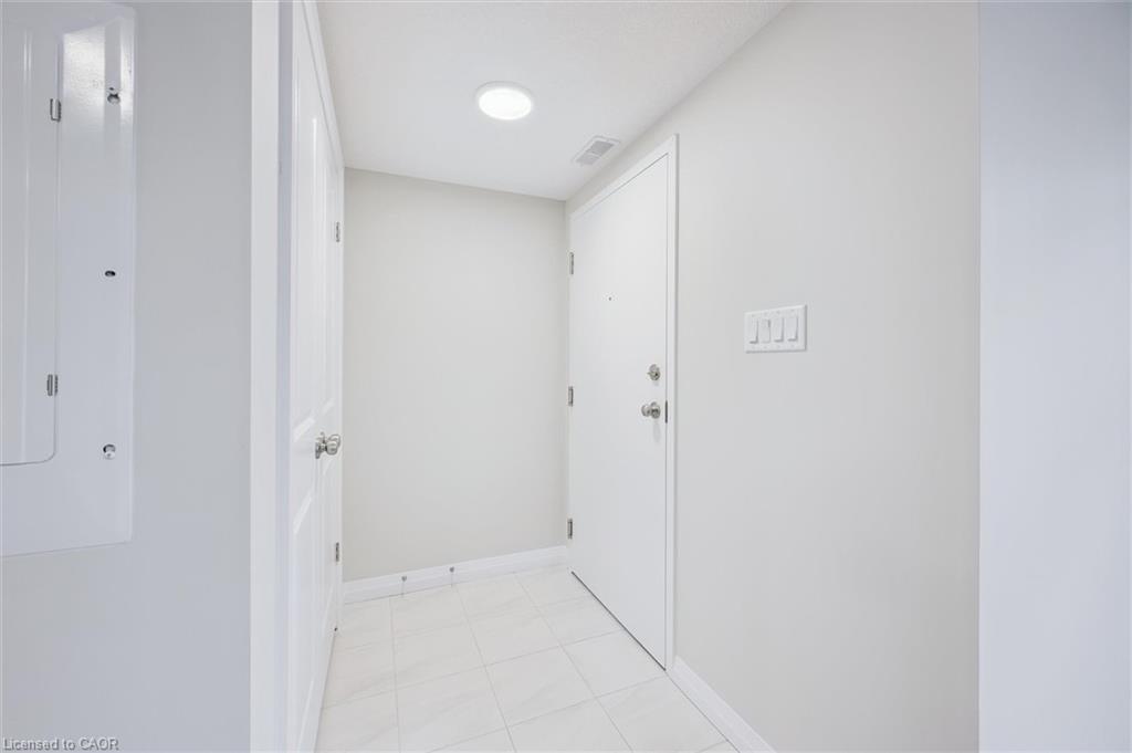 Corridor featuring electric panel and light tile patterned floors