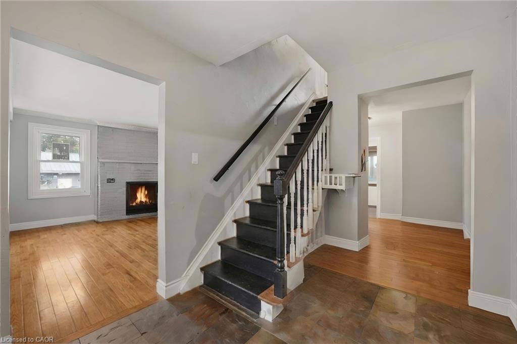 Foyer with a dark-stained staircase, light gray wall paint, and contrasting white trim