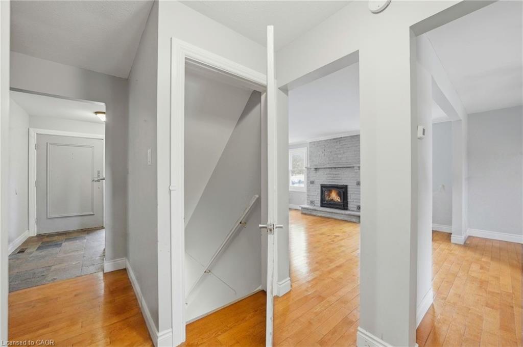 Interior entryway featuring wood-finish flooring, light gray wall paint, a visible staircase, and multiple open doorways