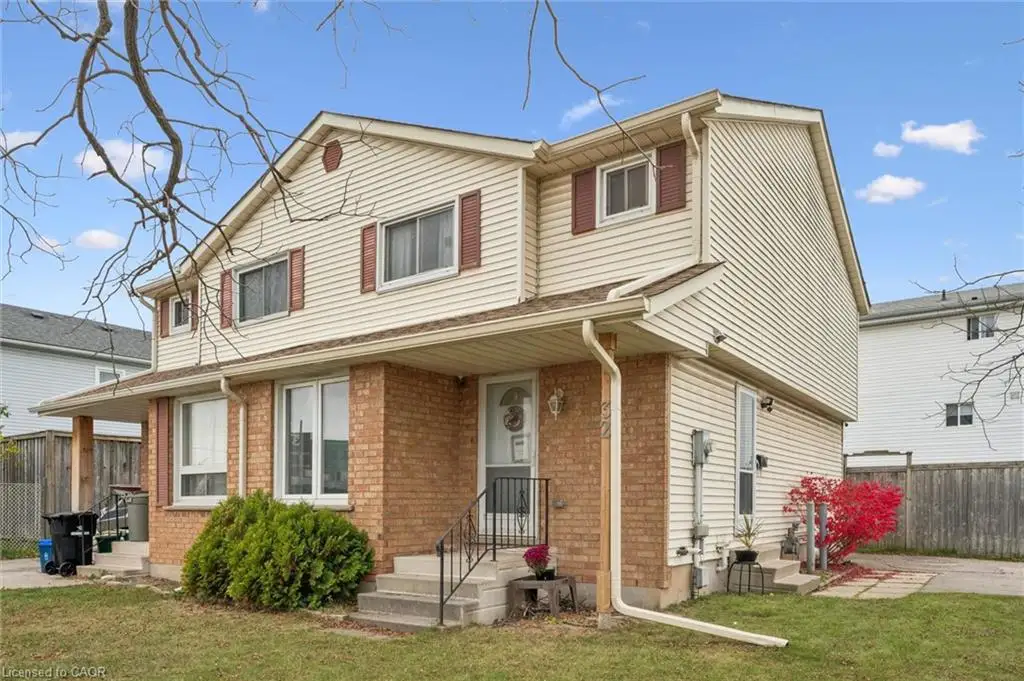 Multi-level exterior featuring brick and vinyl siding, covered front porch, and wrought iron railing