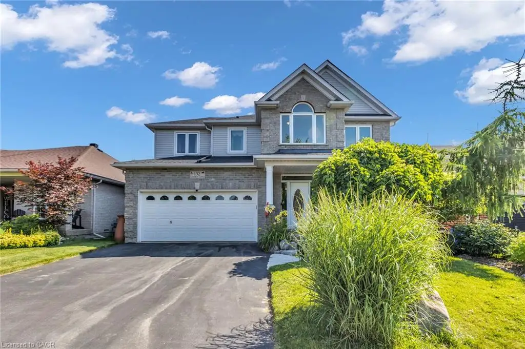 Two-story residence featuring a stone and siding facade, an attached two-car garage, and a paved driveway
