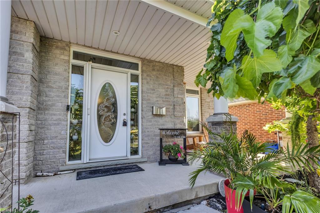 Front entry featuring a white door with decorative oval glass, flanking sidelights, transom window, and stone façade