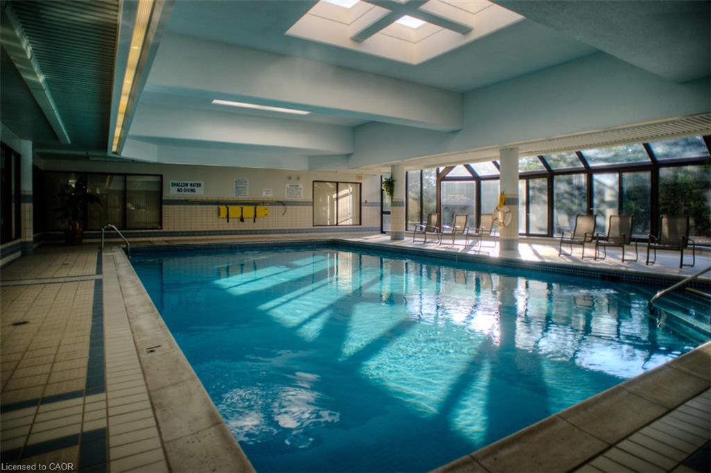 Indoor swimming pool with skylights, extensive perimeter windows, and tiled deck surround