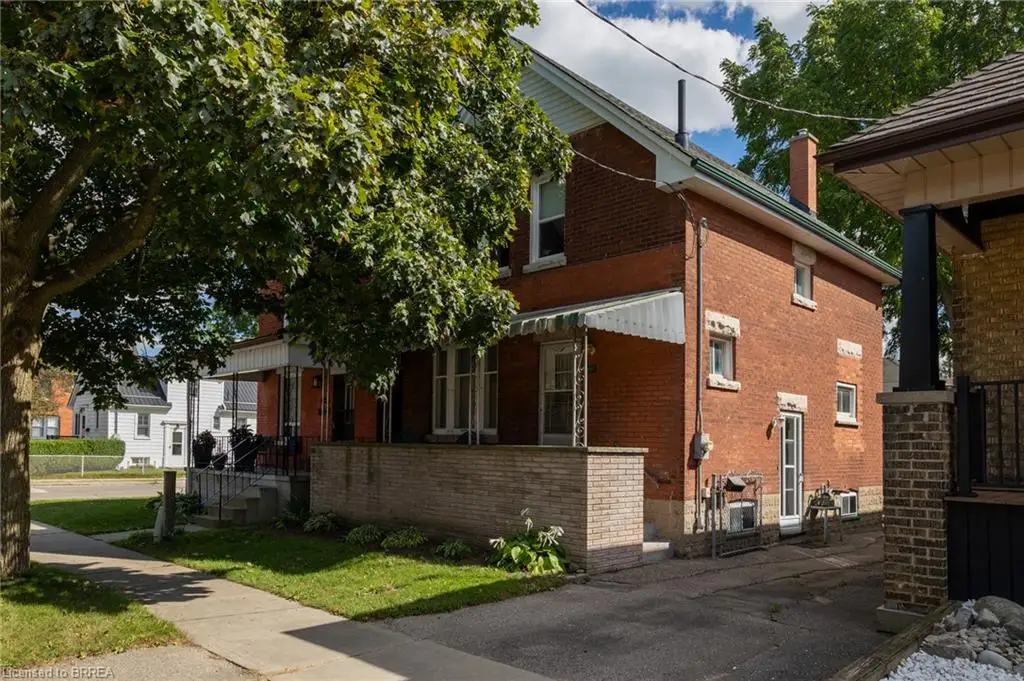 Brick exterior with white window trim and a side entrance