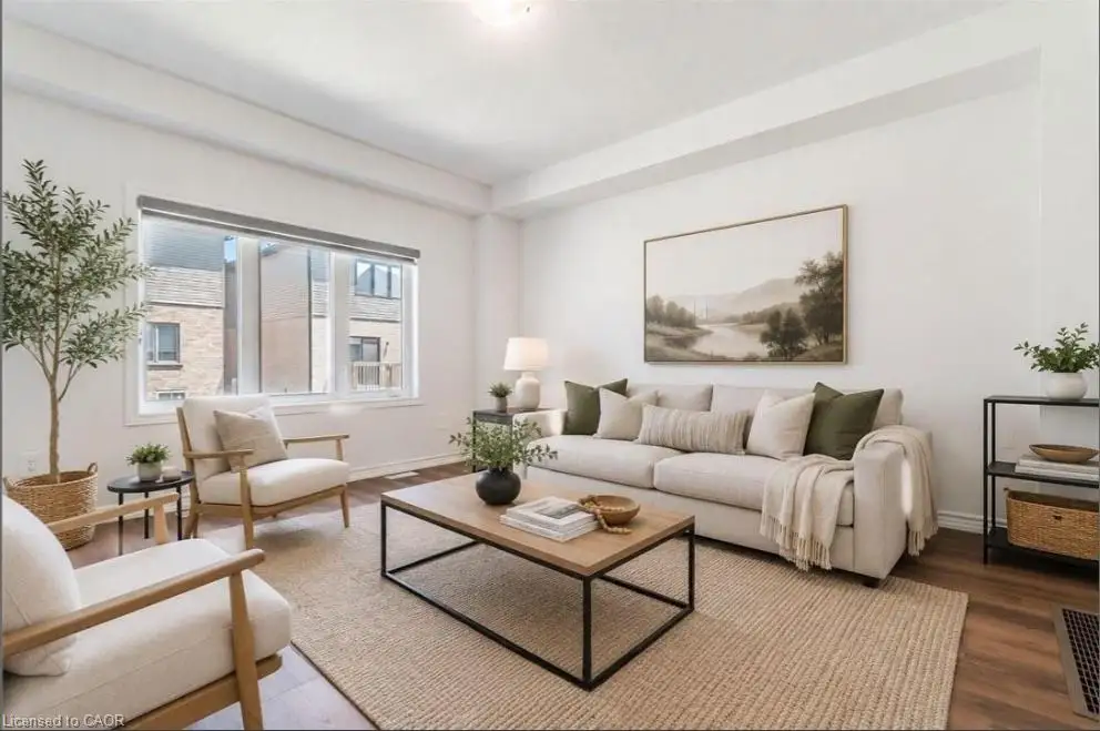 Living area featuring wood-finish flooring, high ceilings with recessed lighting, and large multi-pane windows